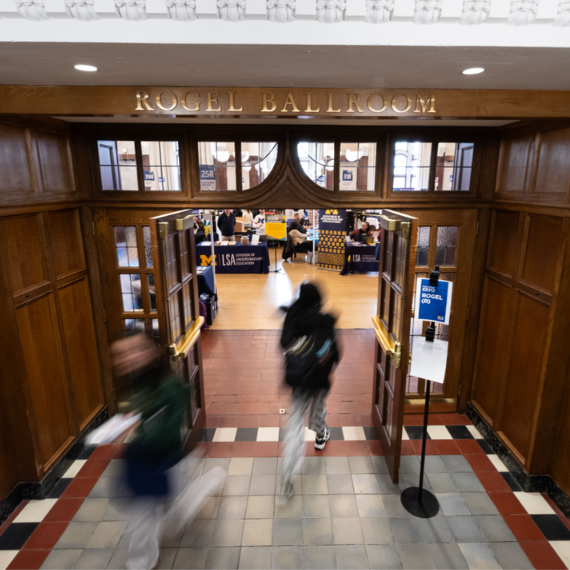People walking in and out of a ballroom.