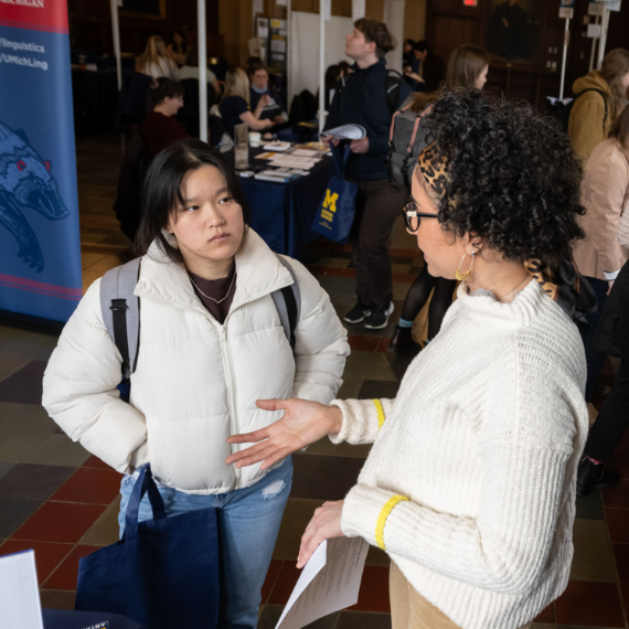 Two people having a discussion at a U-M expo.